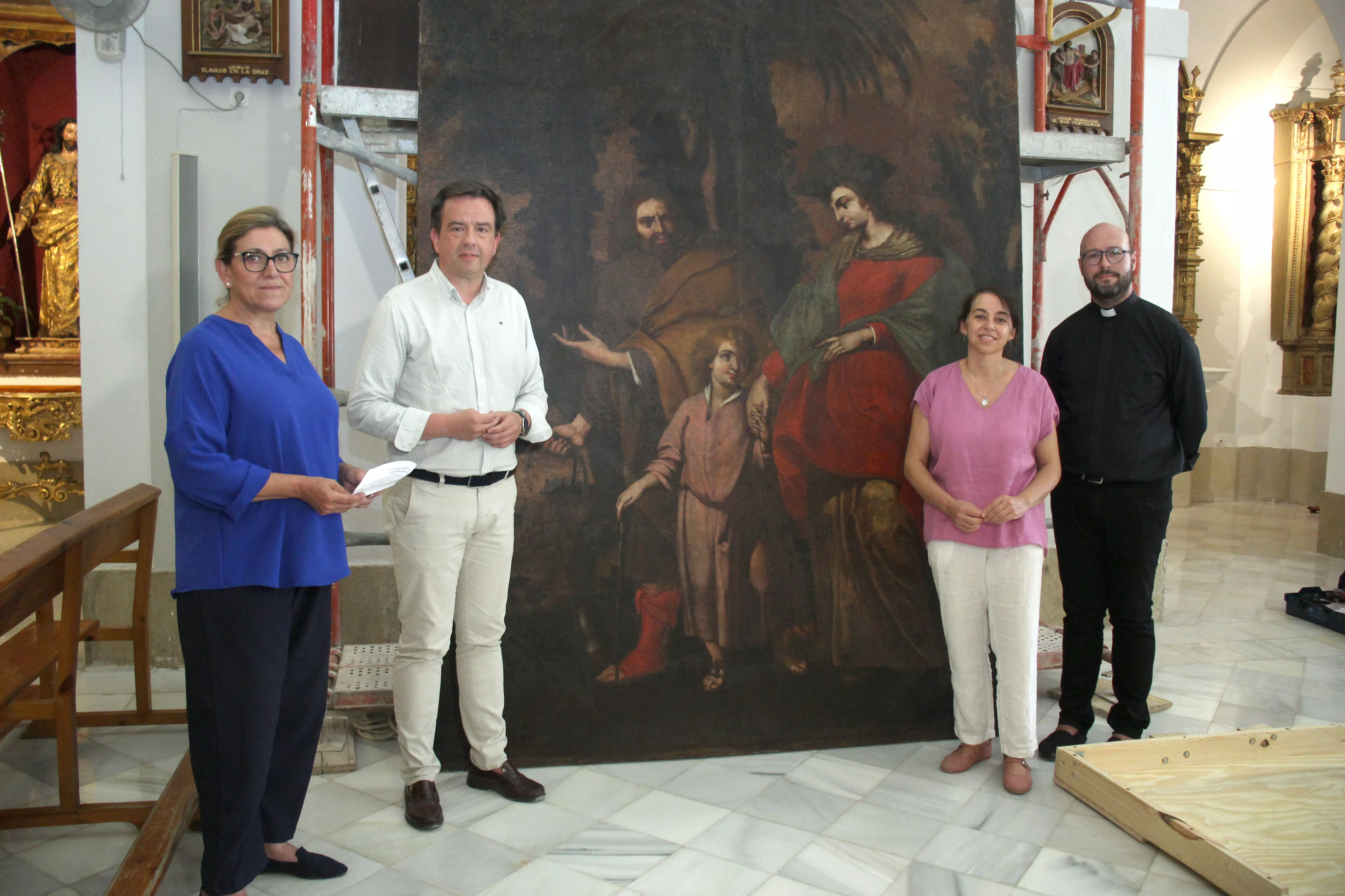 El párroco, la restauradora y el alcalde y la edil de Patrimonio ante el cuadro de Fray Juan del Santísimo Sacramento restaurado