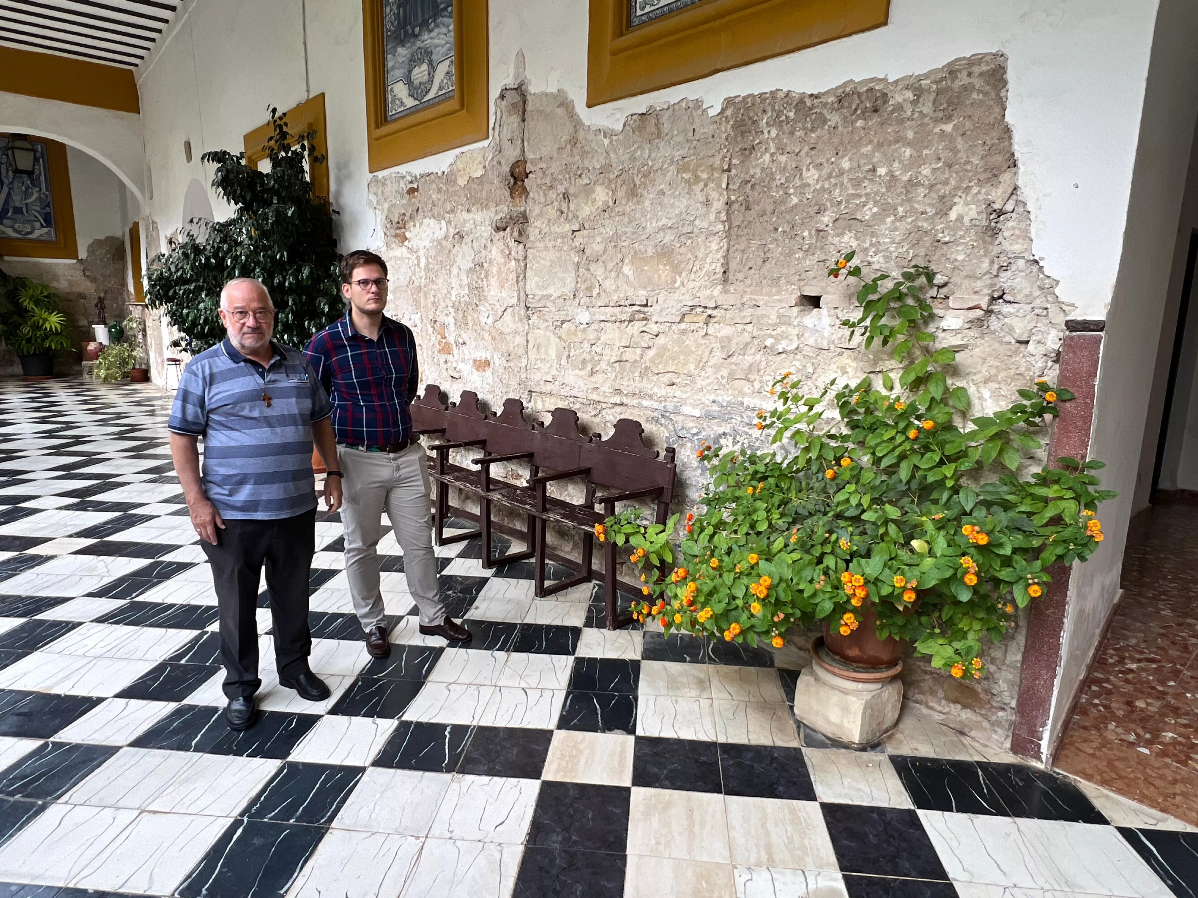 El Padre Antonio y Jesús Ramírez ante uno de los muros del claustro.