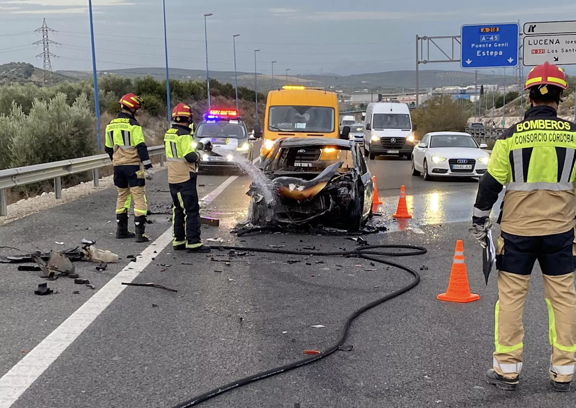 Los bomberos extinguen el fuego declarado en uno de los vehículos siniestrados