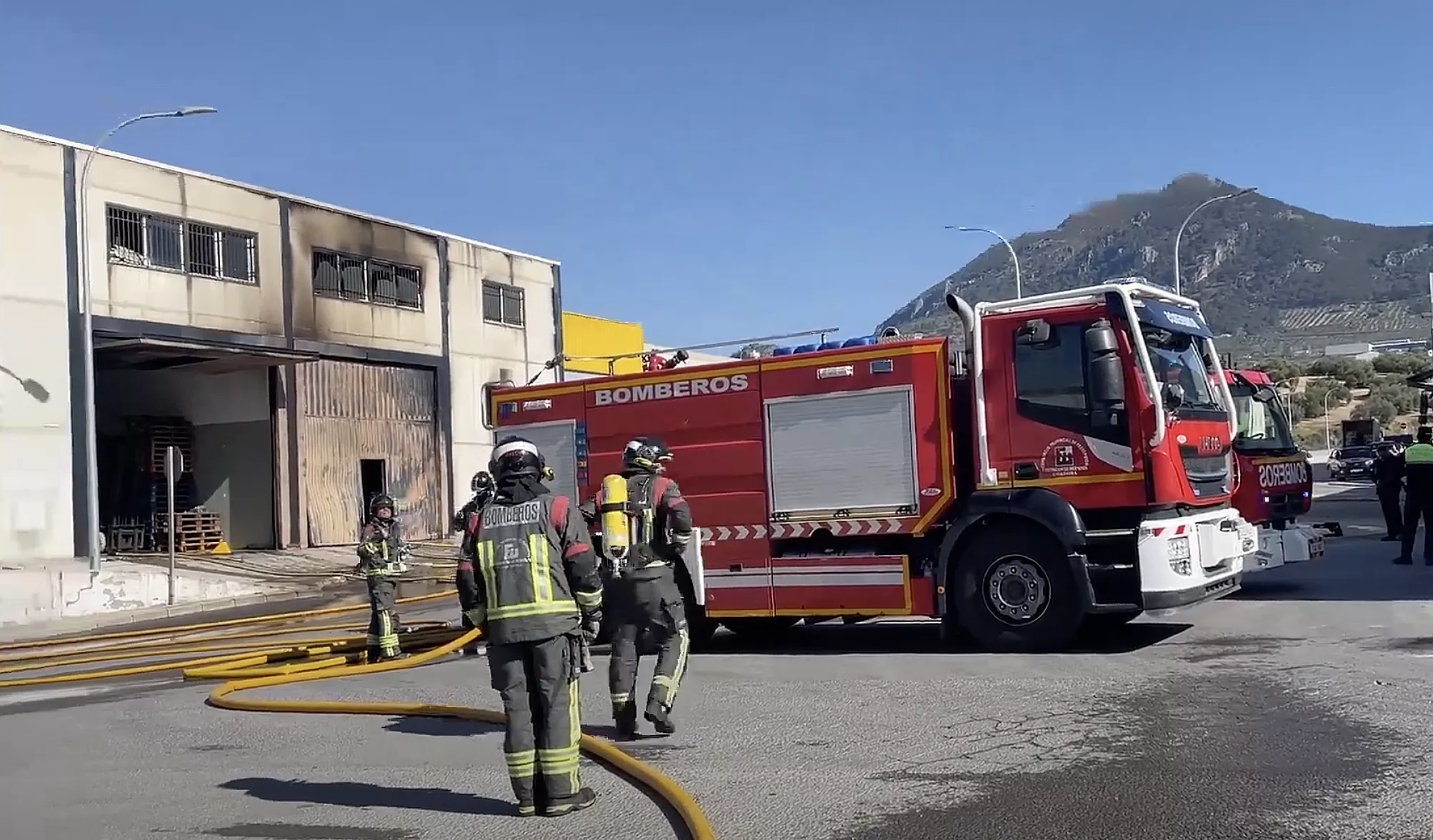 Dotaciones de bomberos junto a la nave siniestrada en Rute